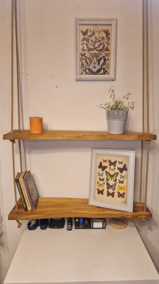 Wooden ladder against a wall with framed artwork and books below
