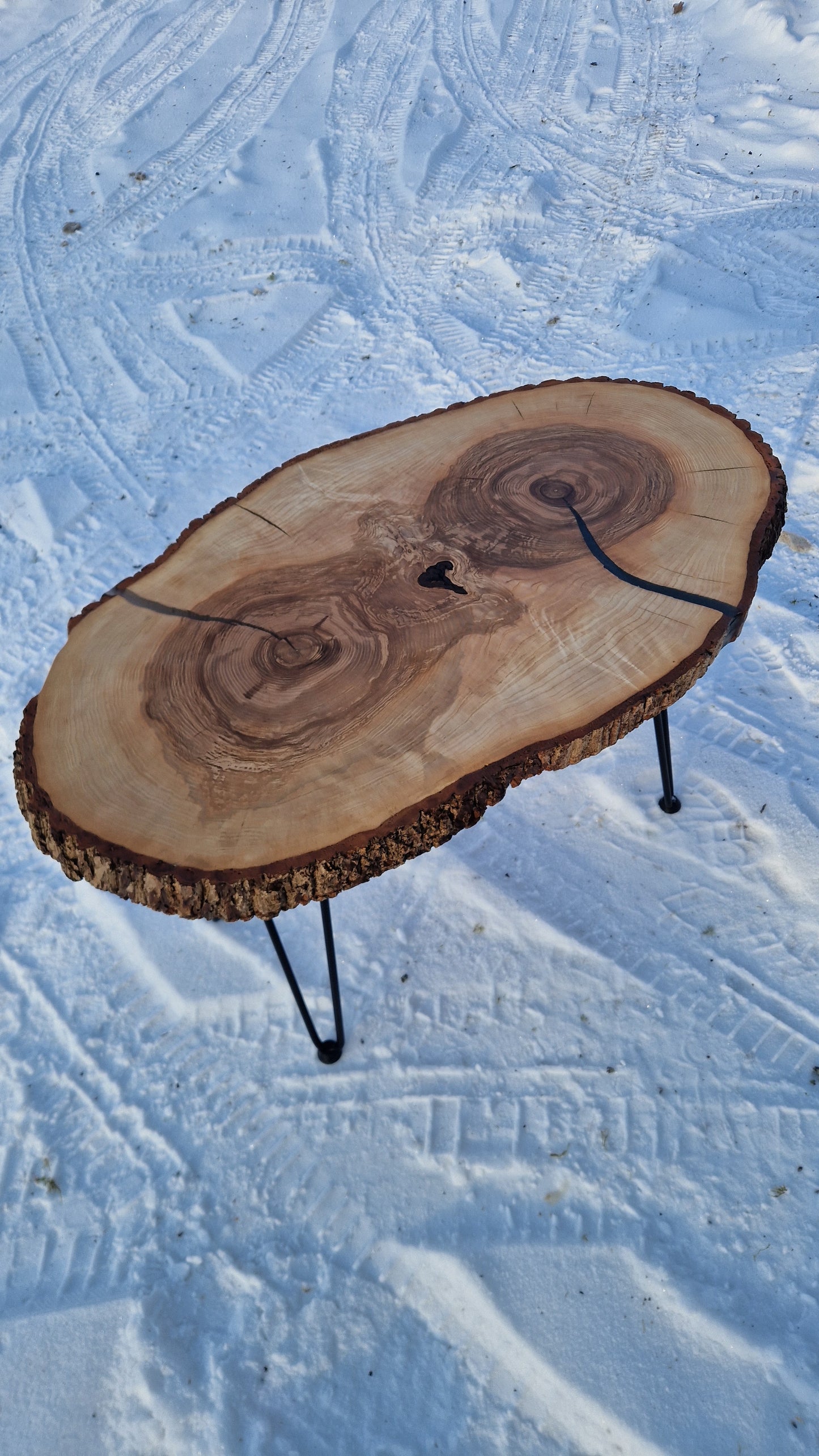Wooden log slice on a stand against a textured snowy background
