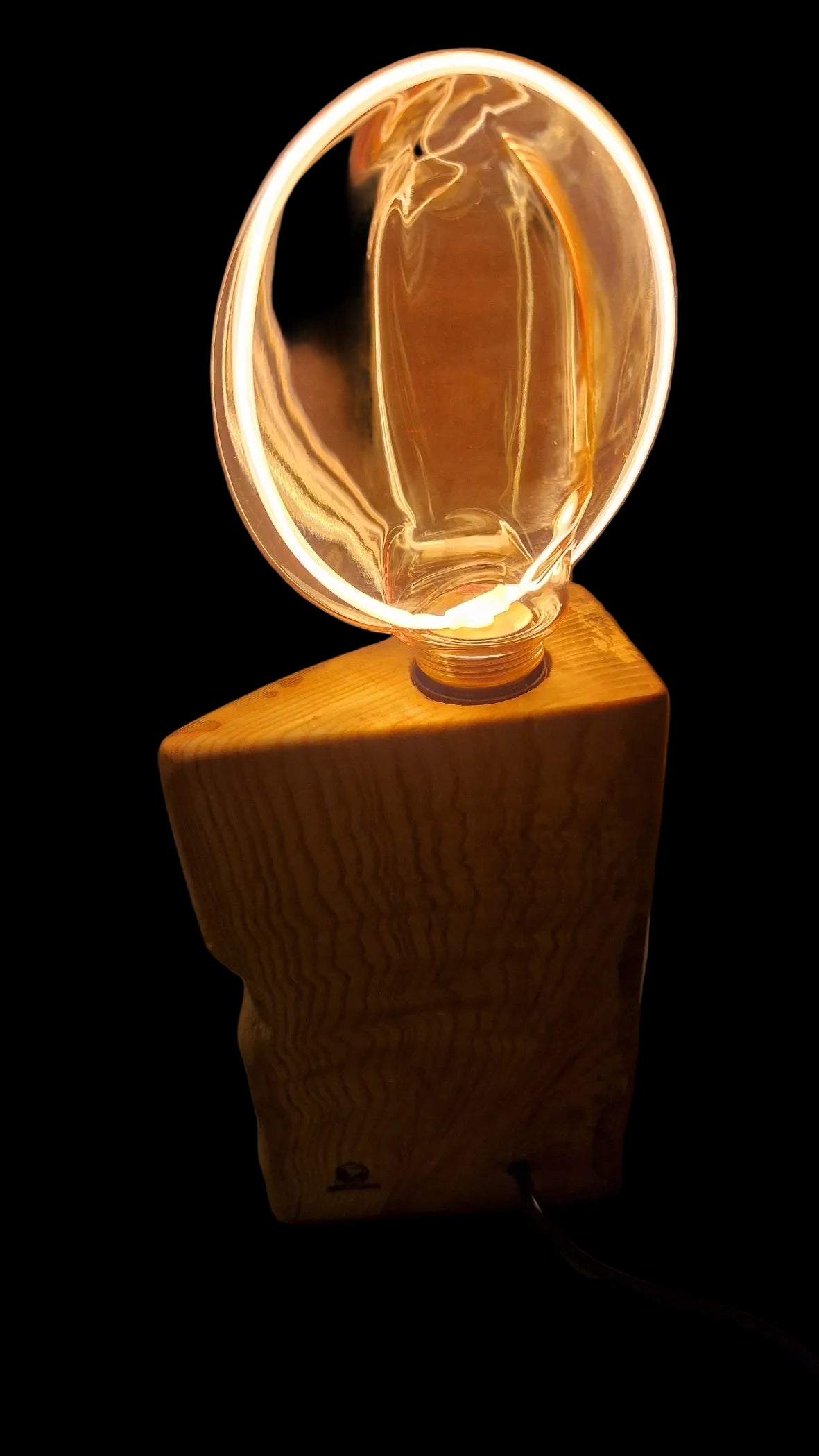 Dimmable rustic wood lamp standing on a neutral background, illuminating the room with a warm golden glow.