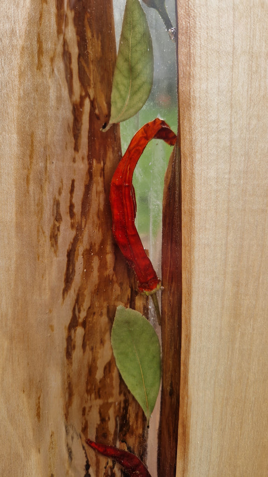 Red chilli pepper embedded in epoxy on a wooden surface
