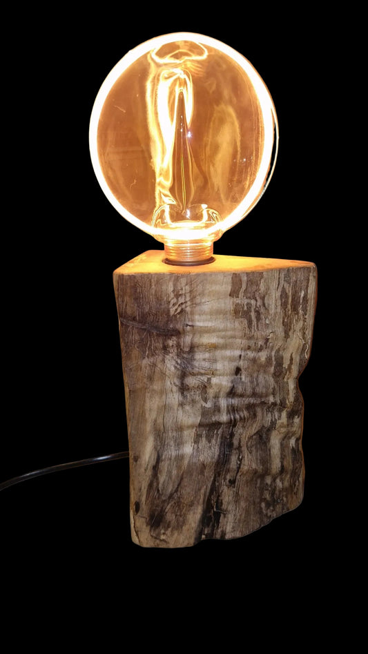 Dimmable rustic wood lamp standing on a neutral background, illuminating the room with a warm golden glow.