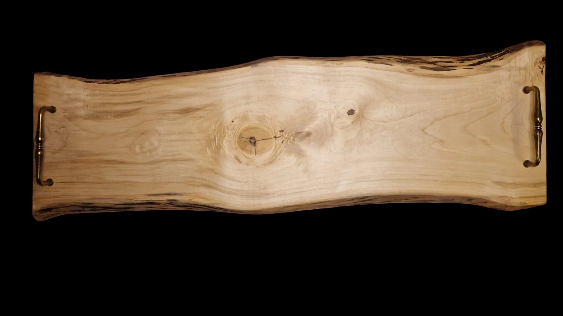 Top view of a long 90cm maple wood live edge serving board with vintage brass handles on a neutral background