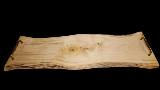 Top view of a long 90cm maple wood live edge serving board with vintage brass handles on a neutral background
